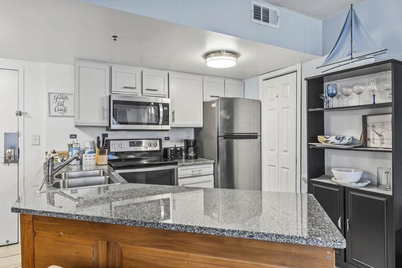 Kitchen with white cabinetry and full-size appliances