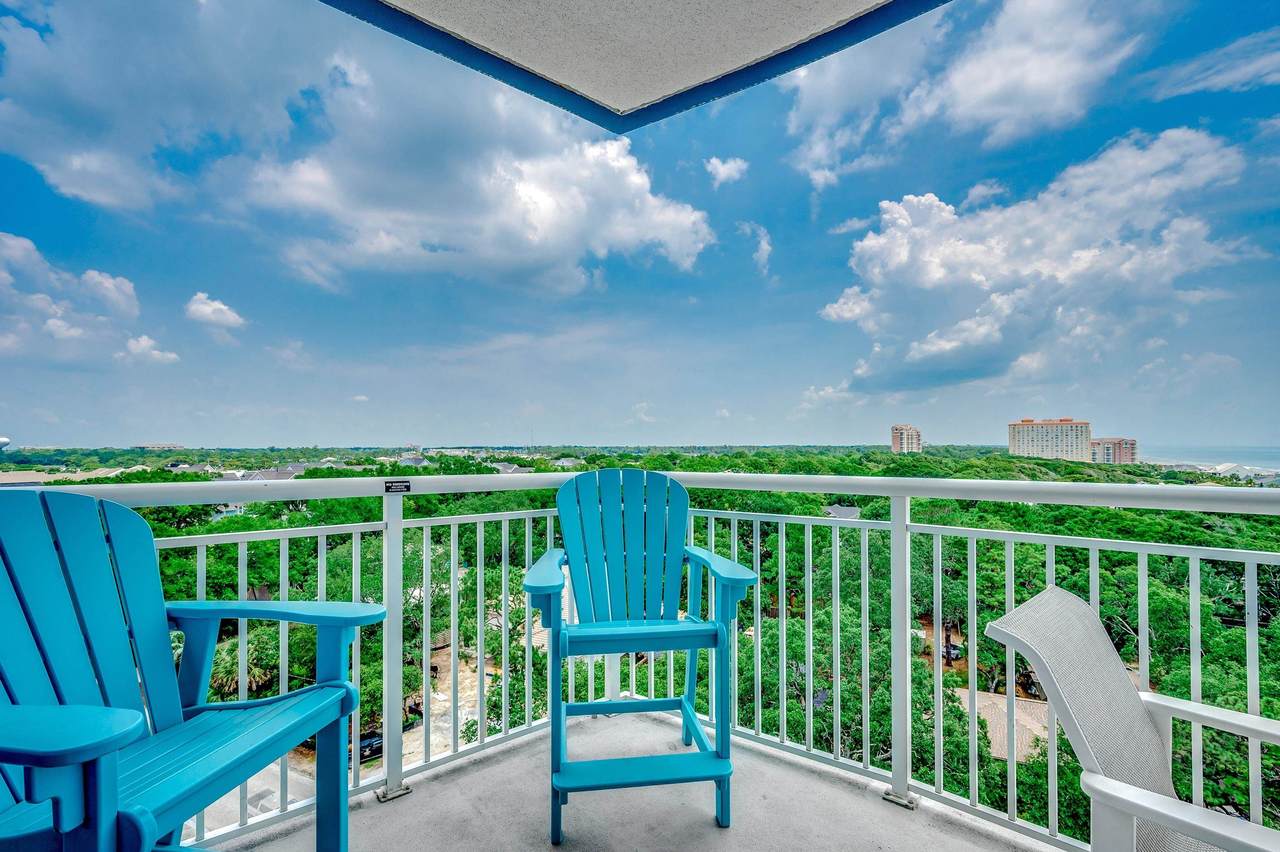 Private balcony with two blue chairs and coastal view