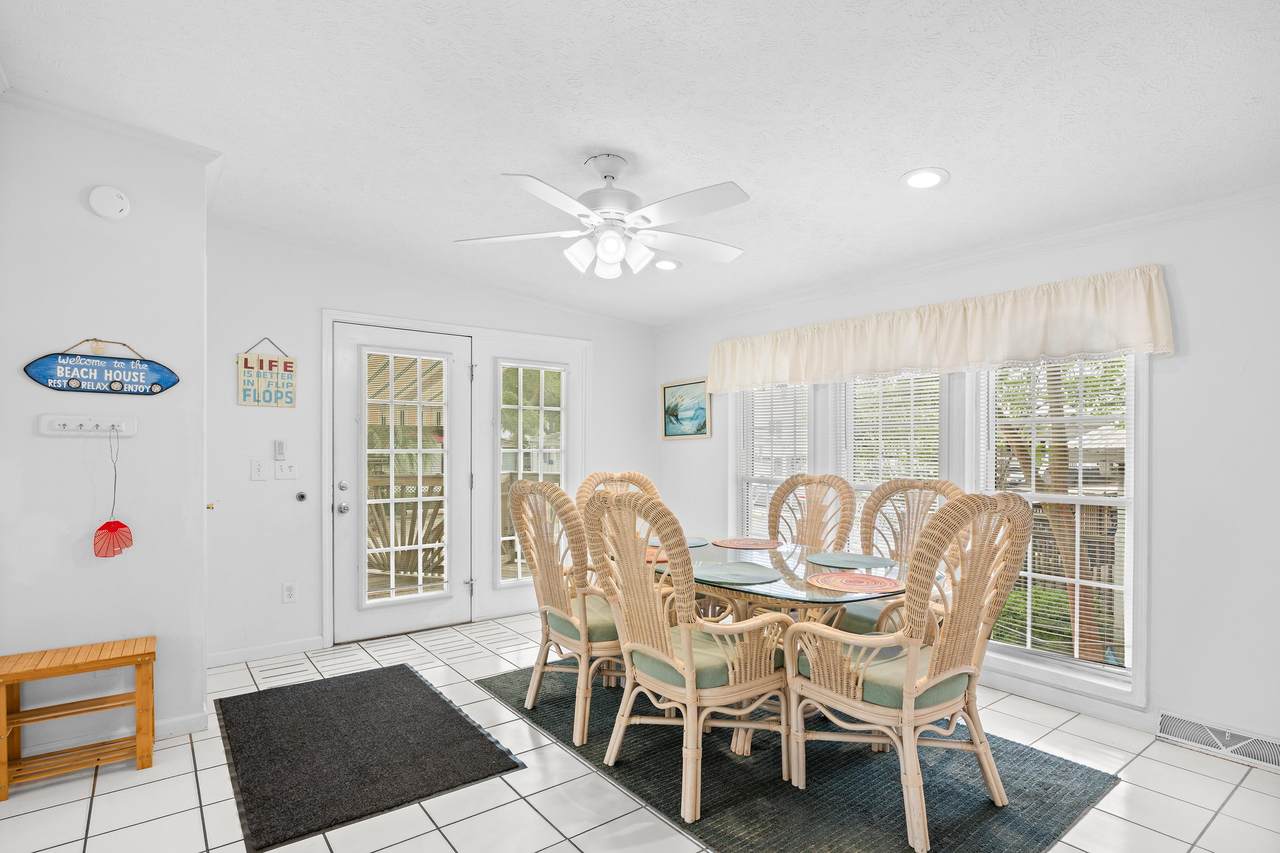 Bright formal dining area with tile flooring and French doors