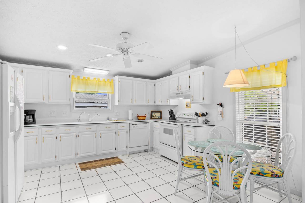 Spacious white kitchen with Corian countertops and plentiful cabinetry