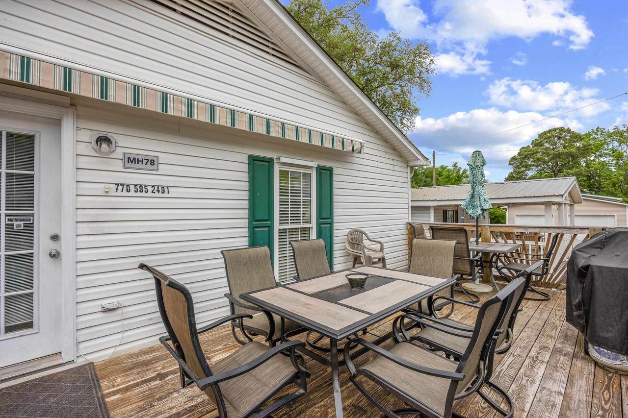 Rear deck with outdoor seating beneath mature trees