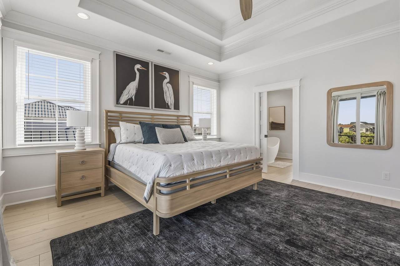 Furnished bedroom with tray ceiling and water views