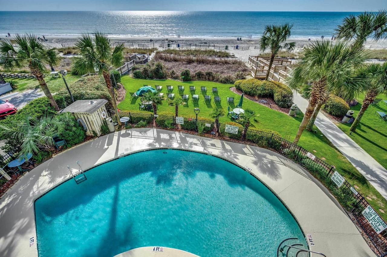 Outdoor swimming pool and oceanfront lawn at The Palms