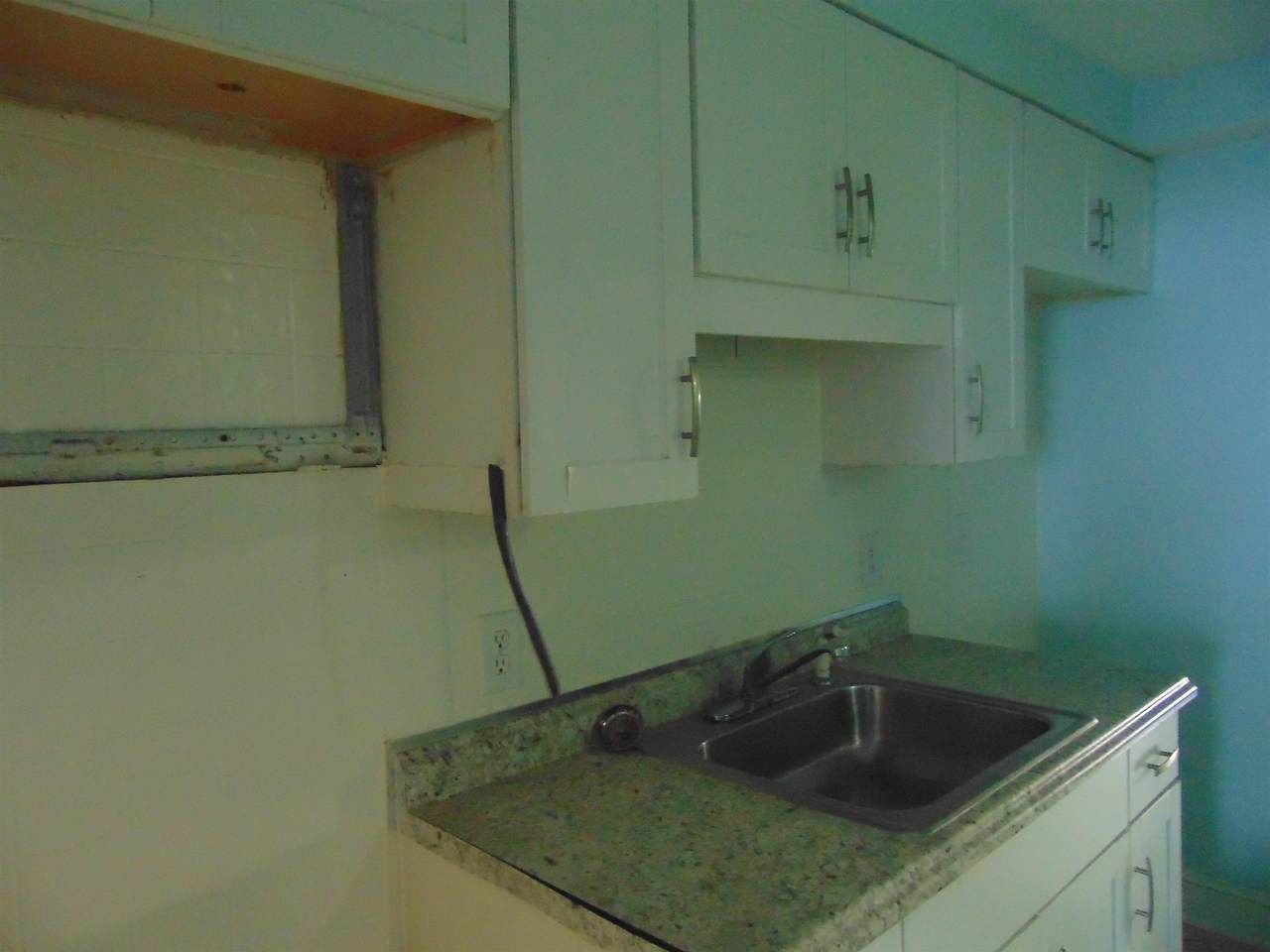 Kitchen work area with sink and unfinished wall section