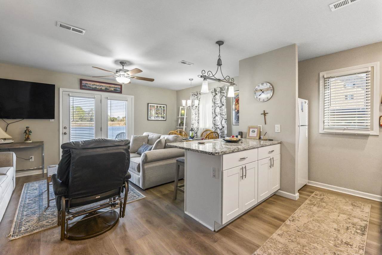 Open kitchen with white cabinetry and a large center work surface