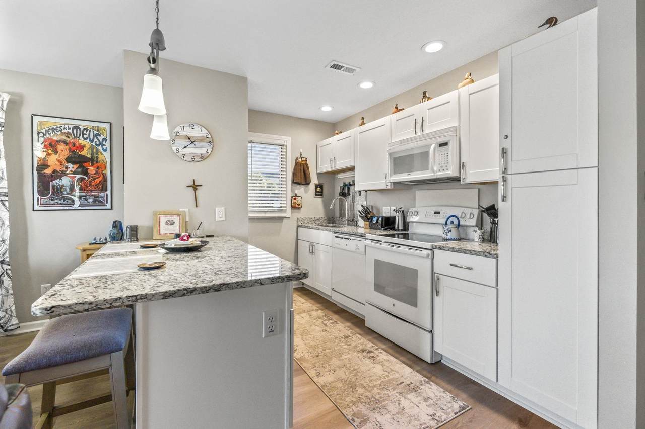 Kitchen with white cabinetry, solid-surface counters and recessed lighting