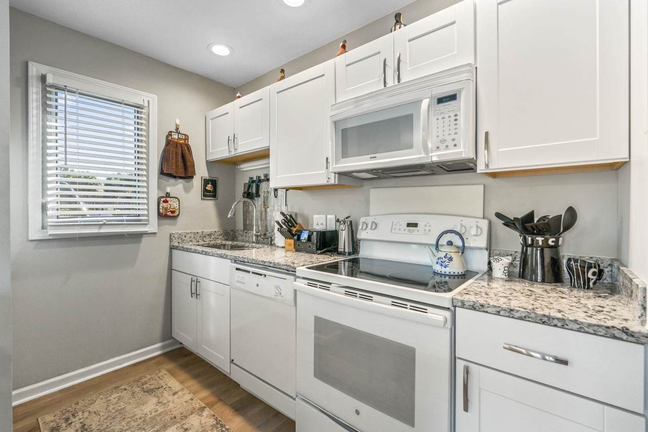 Kitchen wall with white cabinets and included appliances