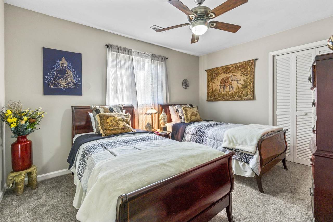 Second bedroom with two beds and ceiling fan