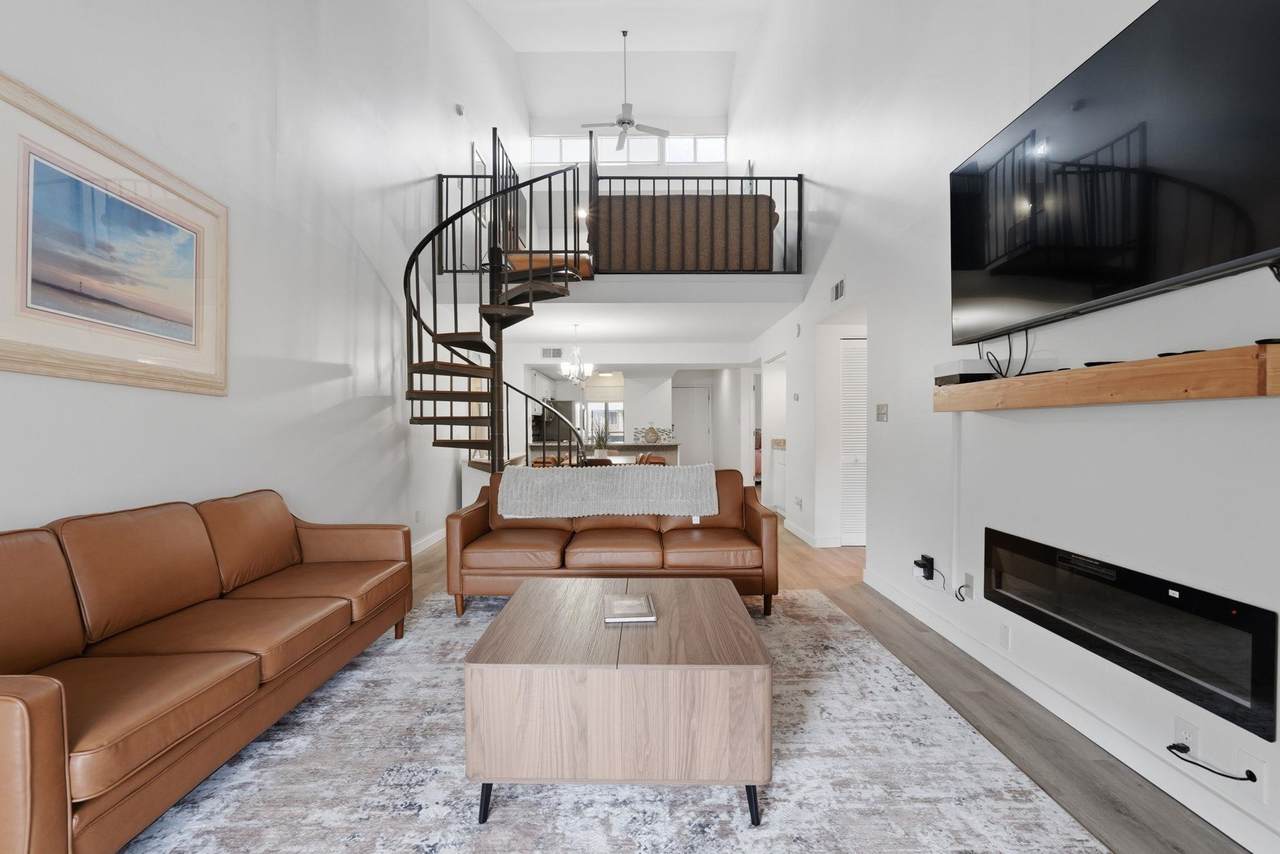 Living room with a spiral staircase and wall-mounted electric fireplace