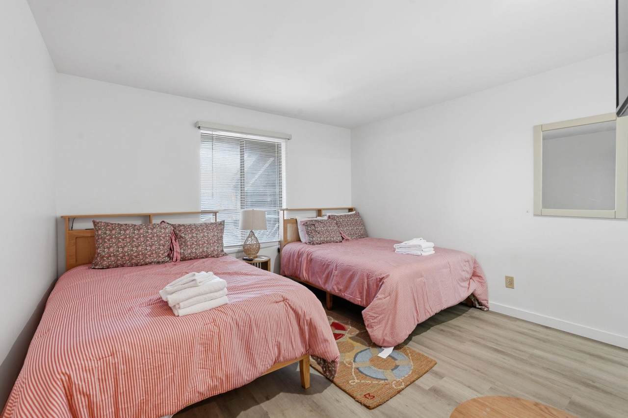 Bedroom with two beds and light wood-look flooring