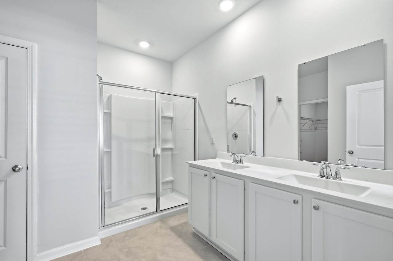 Primary bathroom with double vanity and glass-door shower