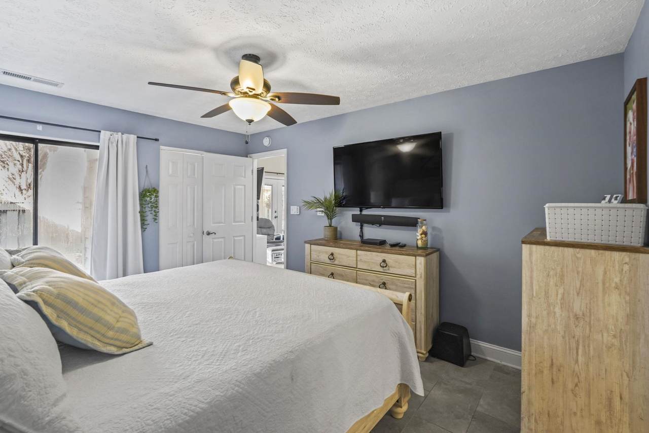 Second bedroom with ceiling fan and television